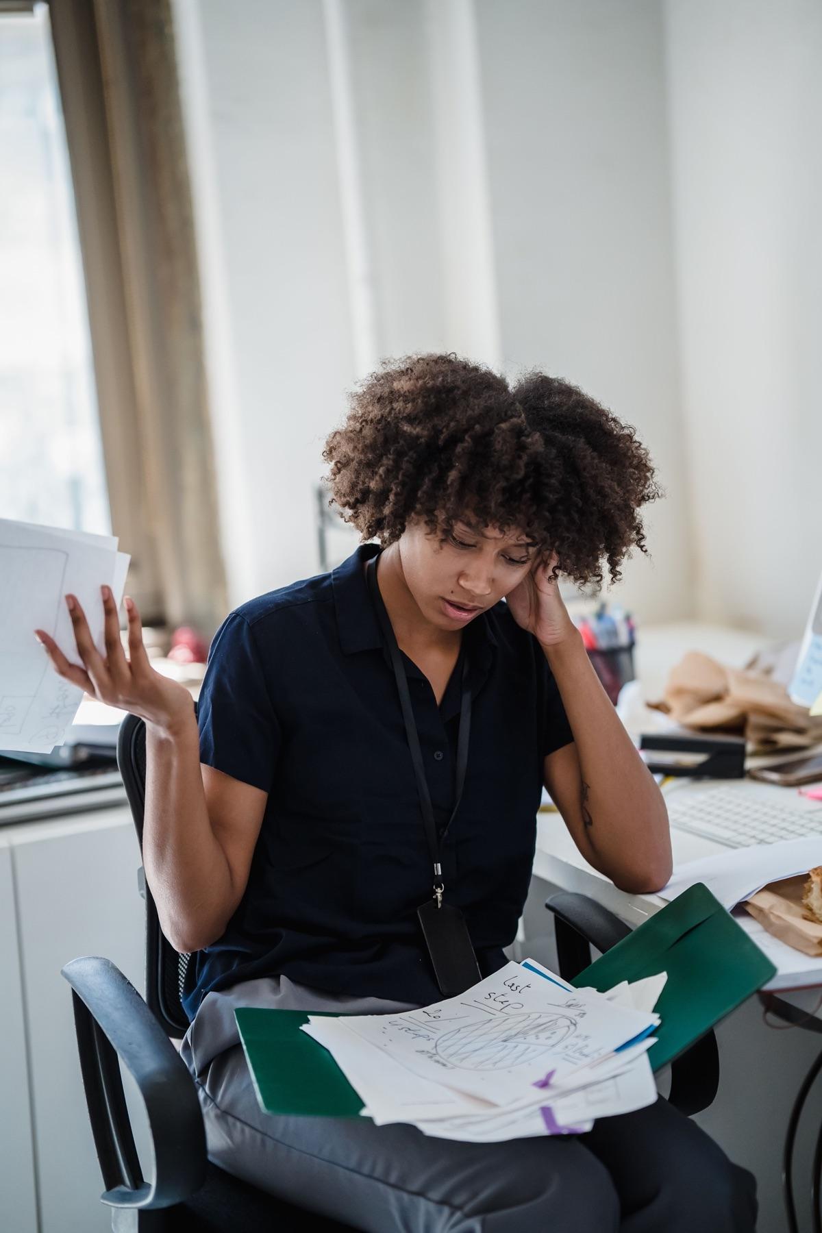 An officer shrugging with loose papers in hand, unable to find a document